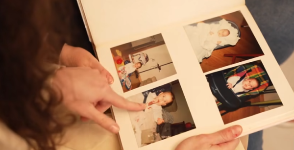 Captura de entrevista de Antena 3 a Noelia mirando el album de fotos de su infancia